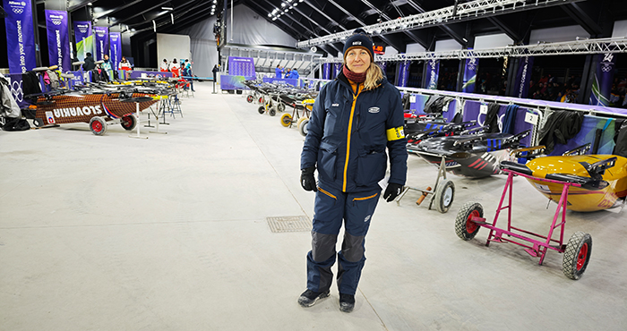 Cathleen Martini steht neben den aufgereihten Zweierbobs